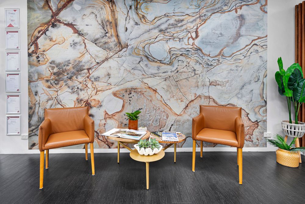 Marble-patterned wall with brown and grey veining serves as a dramatic backdrop in a modern office space.