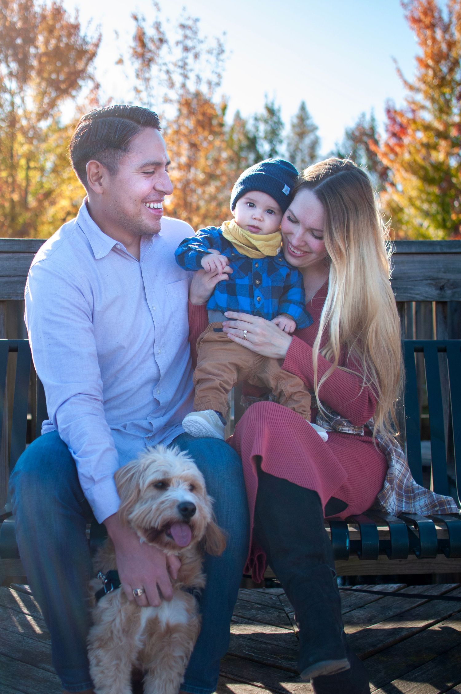 Family with infant and dog posed outdoors