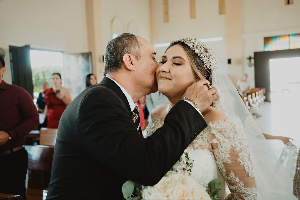 The father giving a kiss to his daughter before handing her over at the altar, a touching gesture
