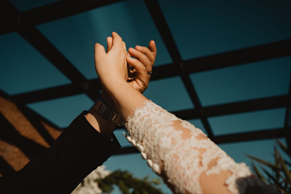 The couple's hands intertwined, pointing to the sky, symbolizing their everlasting bond