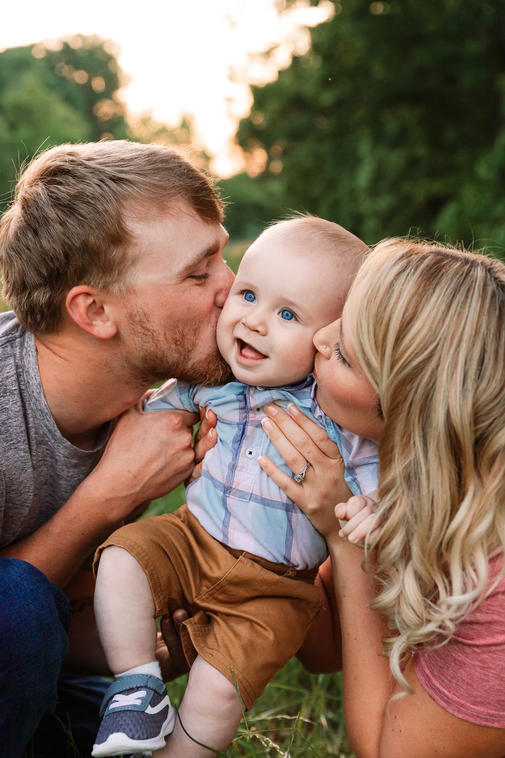 Family sharing sweet kisses with baby during sunset photo session outdoors.