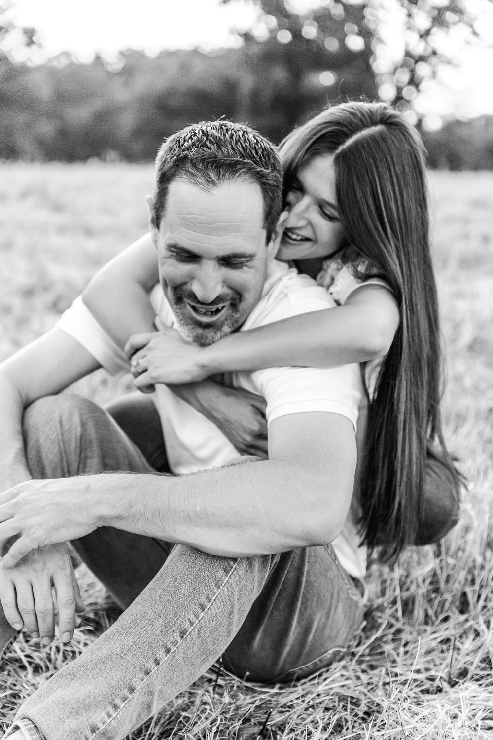 Black and white photo series of couple sharing intimate laughing moments on the ground.