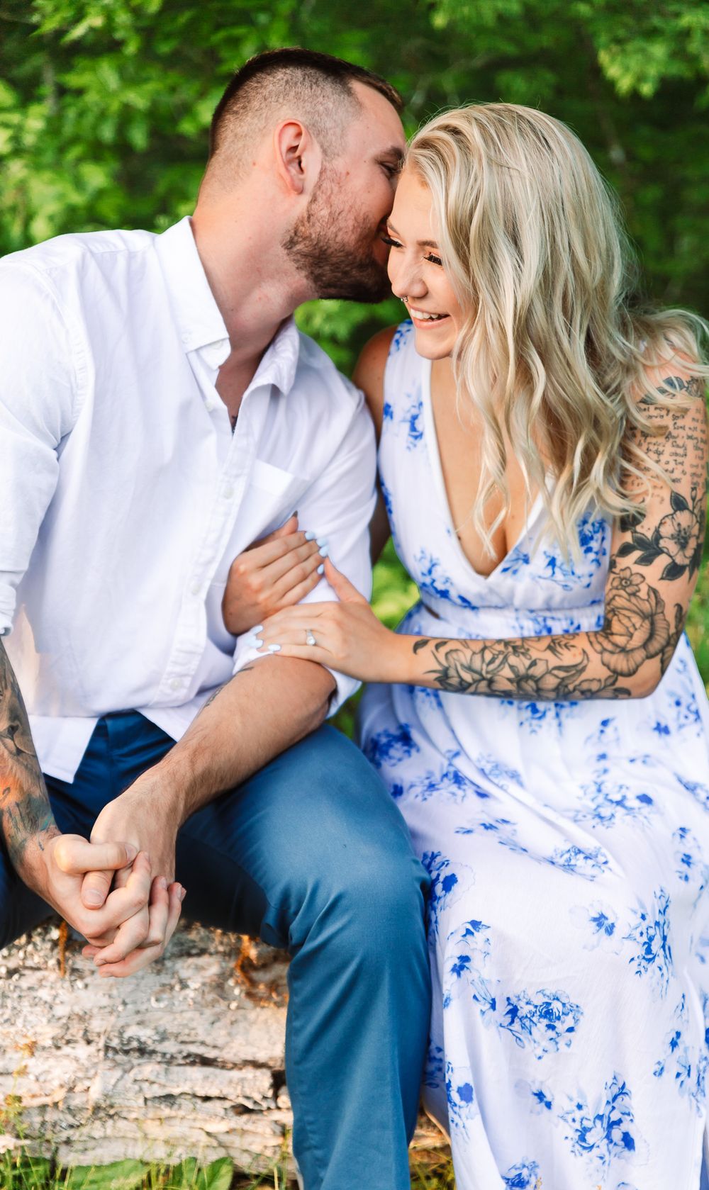 Intimate portrait series of couple sitting together on rustic log outdoors.