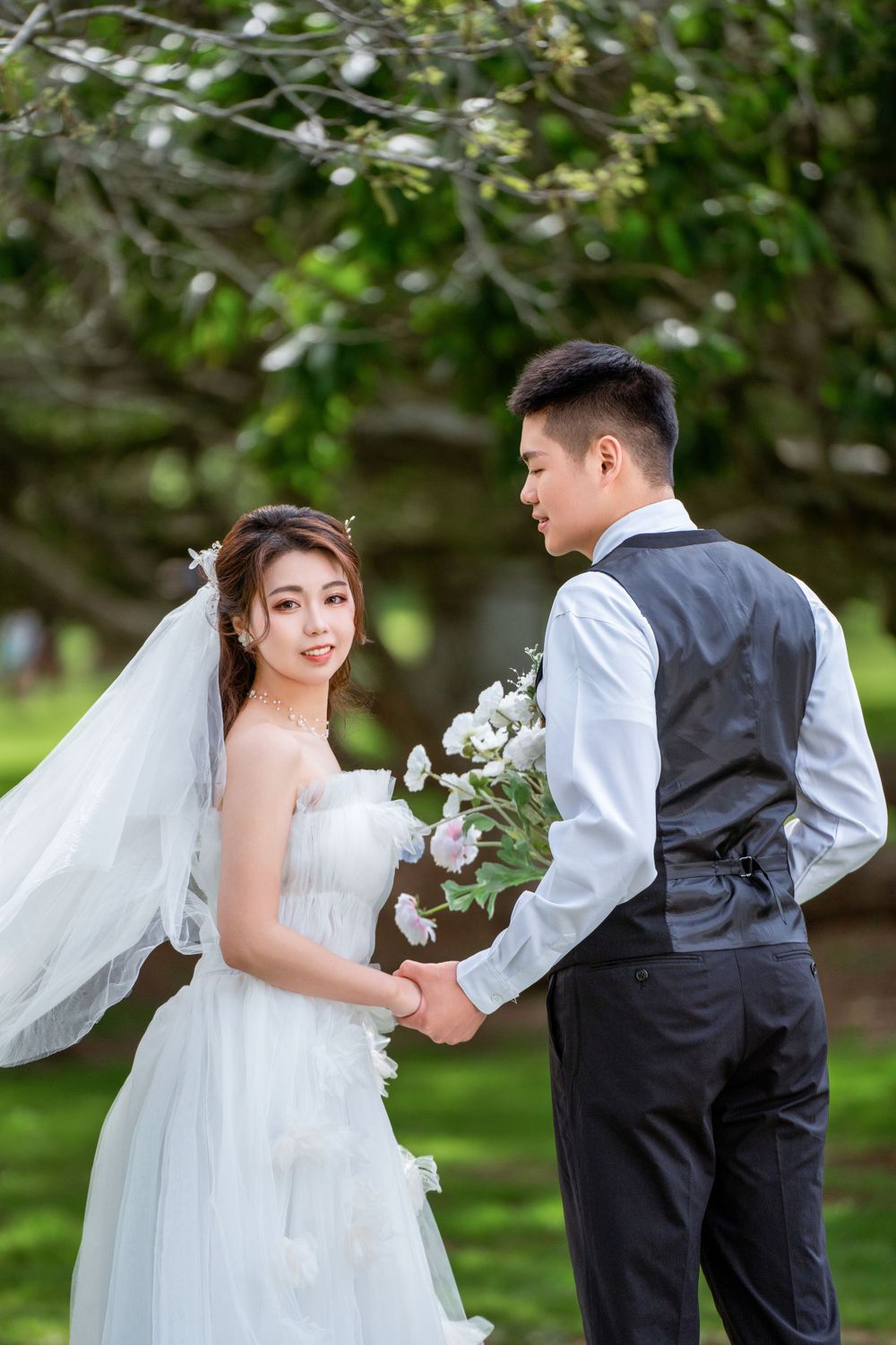 Beautiful outdoor wedding photography of a couple among green trees at One Tree Hill, by an Auckland wedding photographer.