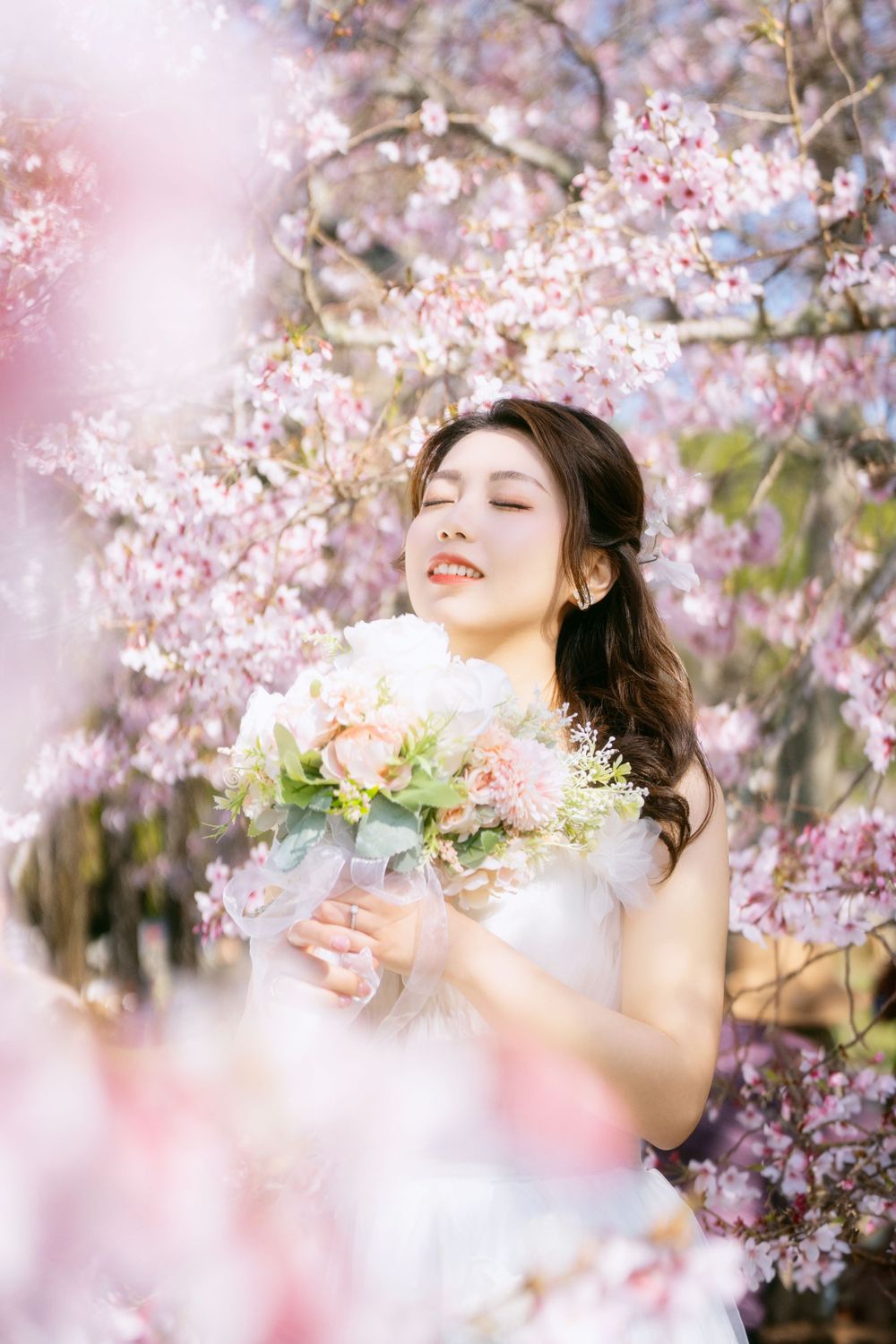 Romantic cherry blossom wedding photography featuring a couple in spring bloom, captured by an Auckland wedding photographer.