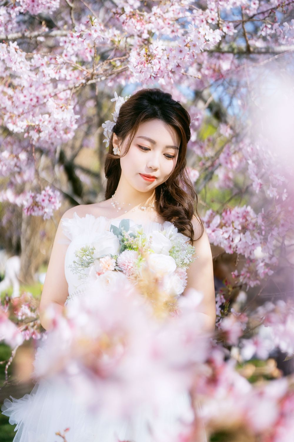 Romantic cherry blossom wedding photography featuring a couple in spring bloom, captured by an Auckland wedding photographer.