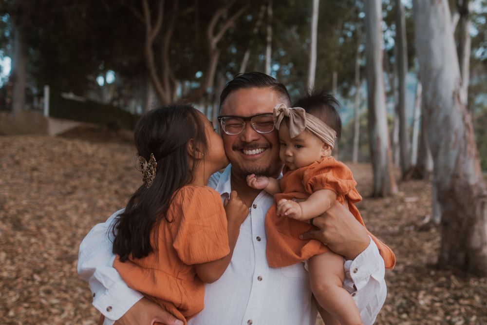 A cheerful family photo showing pure joy and laughter among eucalyptus trees.
