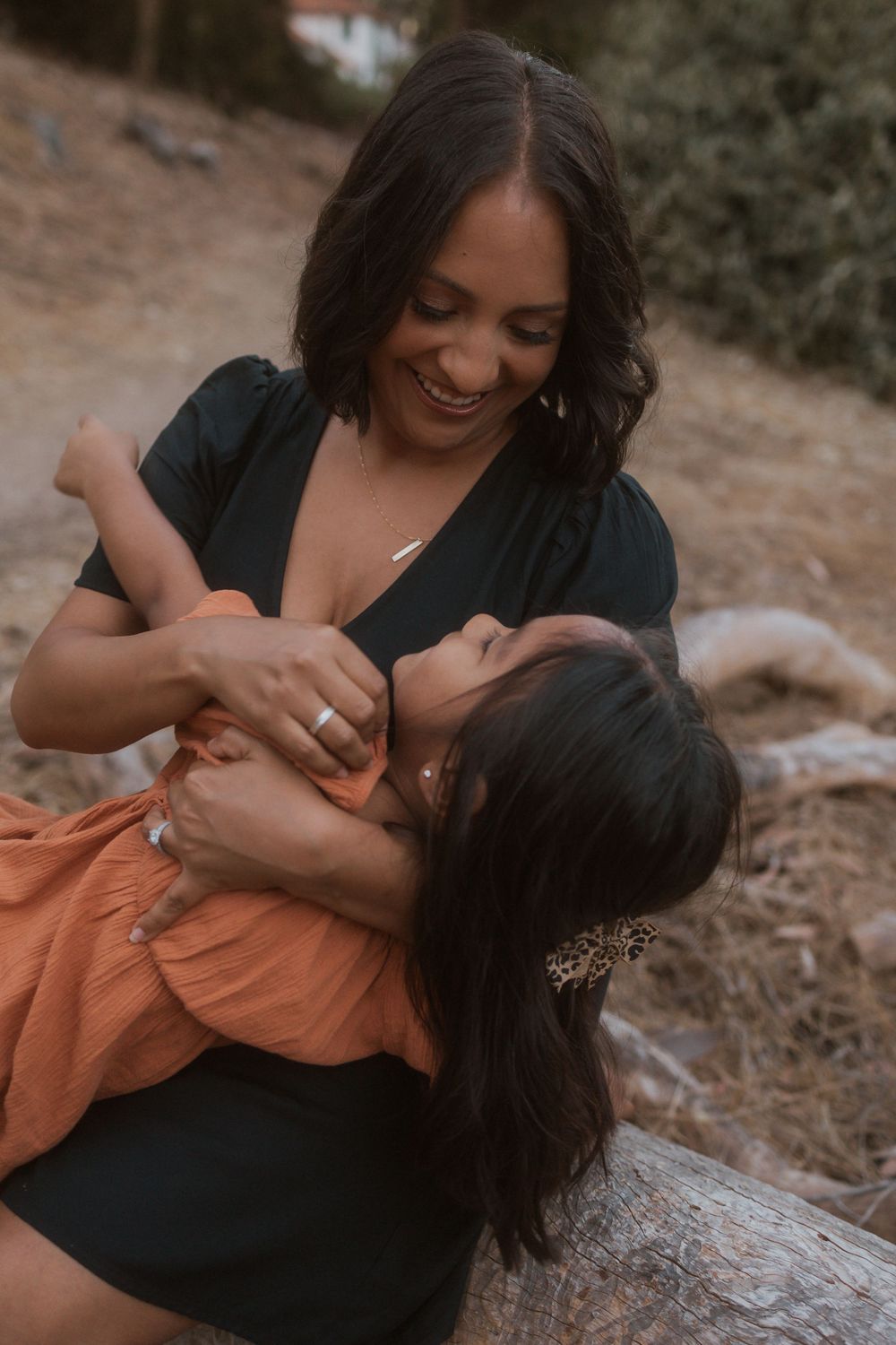 A candid moment of play and laughter between parent and child in nature.
