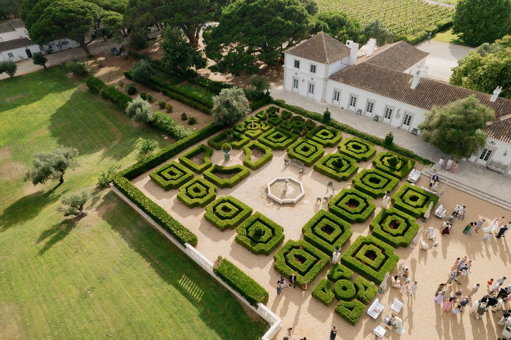 Aerial views of an elegant French formal garden with intricate geometric patterns and manicured hedges at a historic mansion.