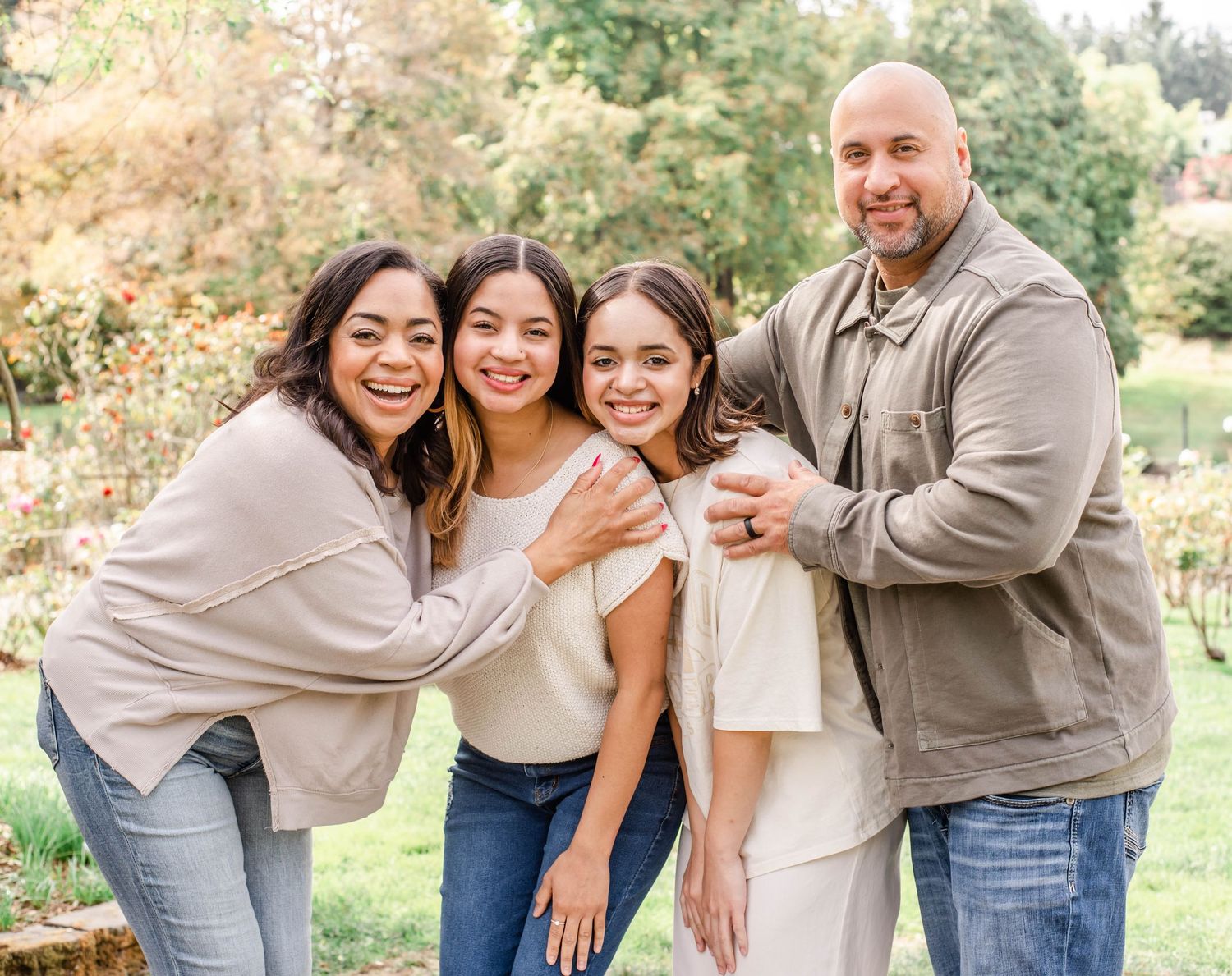 Happy family members share joyful moments and laughter during an outdoor photoshoot in a park.