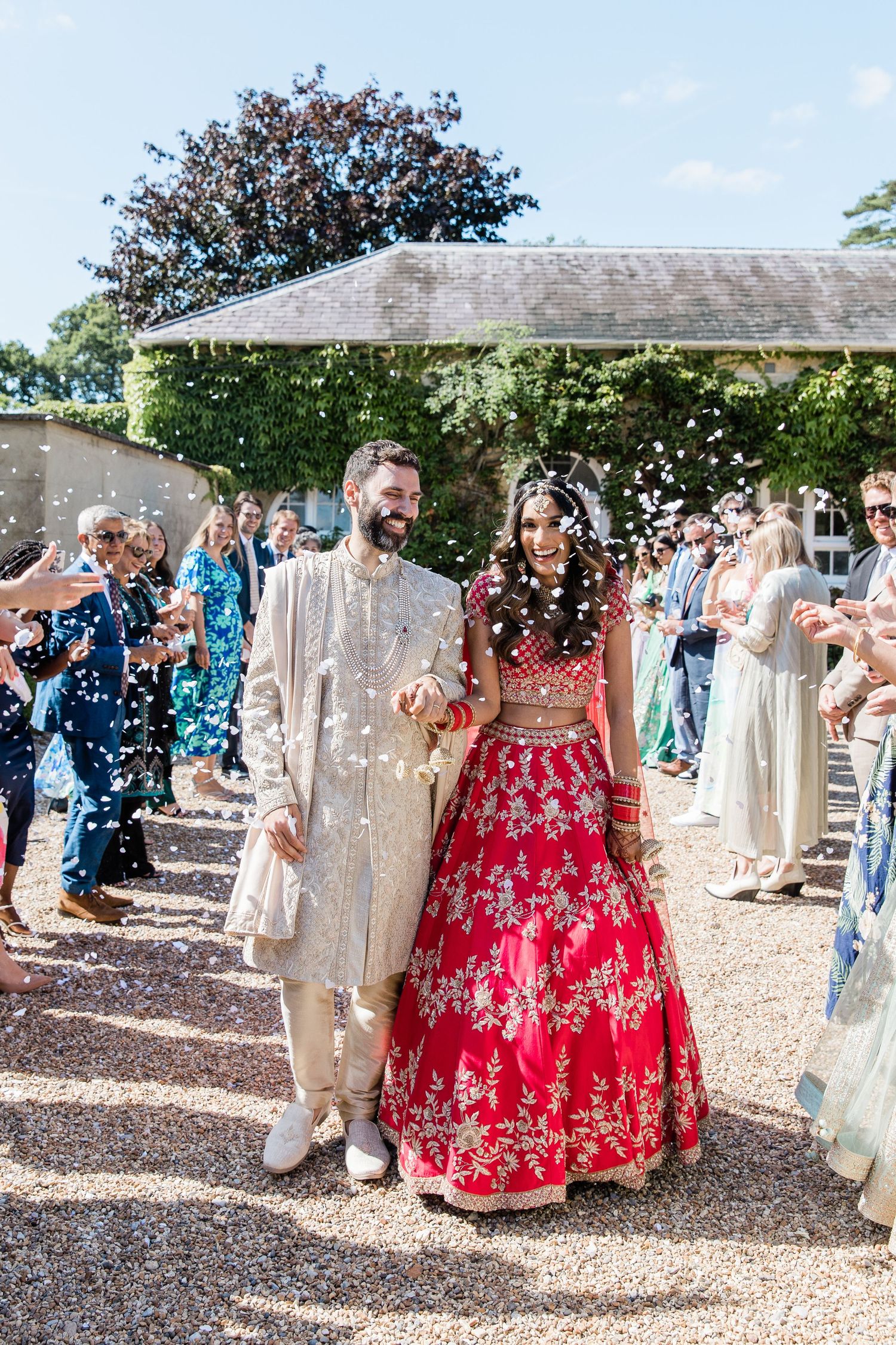 Wedding guests celebrate with confetti during outdoor ceremony at rustic venue.