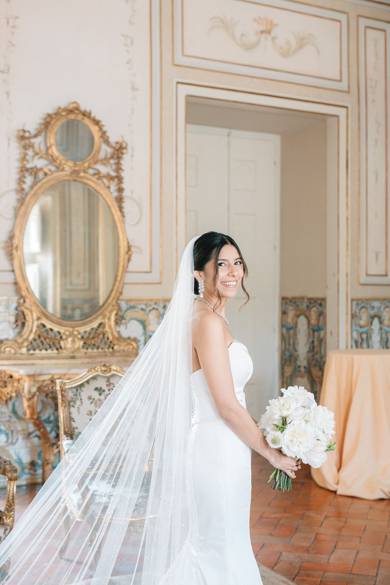Bride portrait with long veil holding bouquet inside Palácio de Fronteira Lisbon palace room