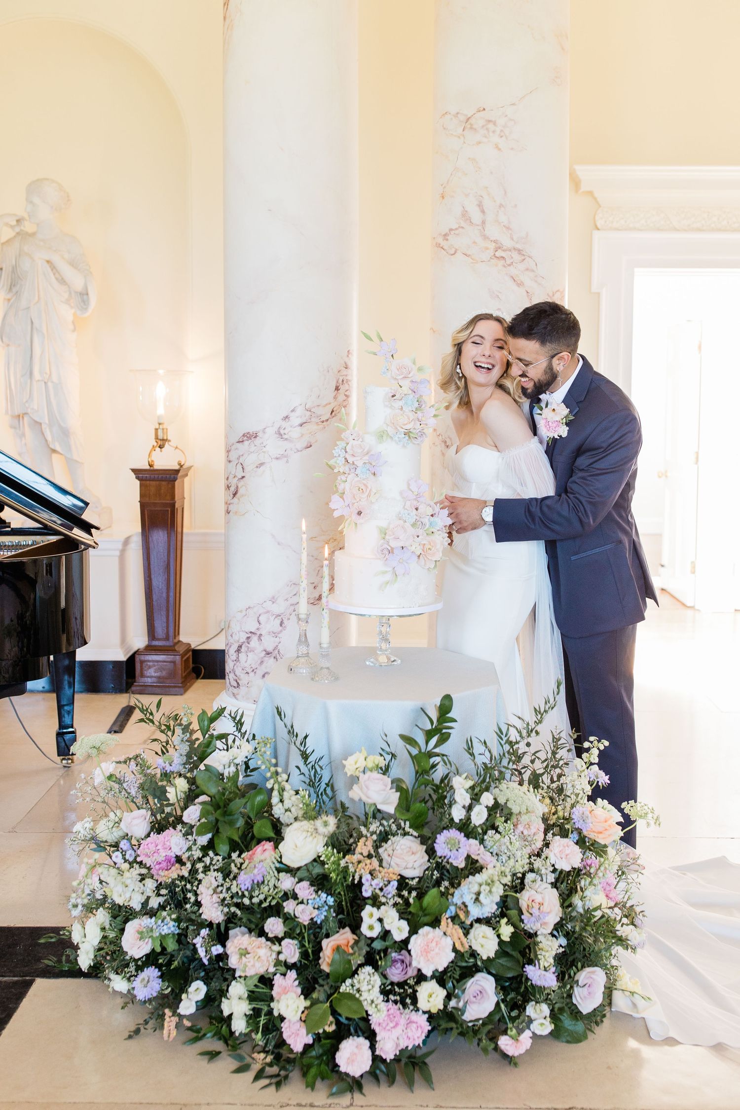 Elegant wedding venue decorated with lush white and pink floral arrangements against classical white pillars.