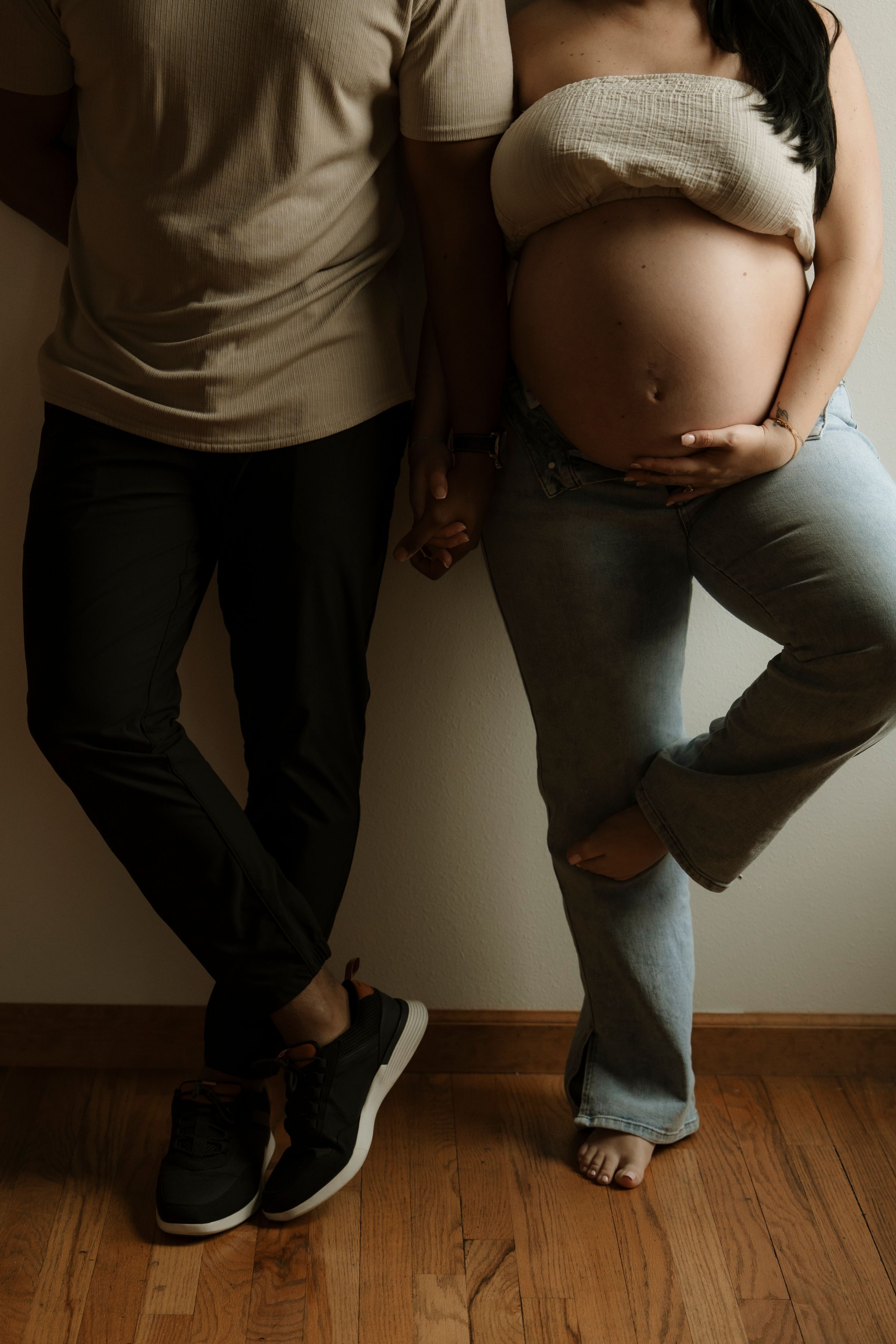 A series of intimate maternity photos showing a pregnant belly and bare feet on hardwood floors.