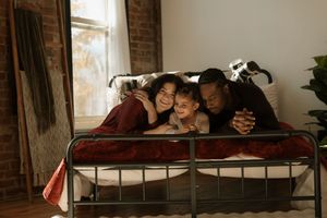 People relaxing and lounging together on a couch in a rustic room with exposed brick walls.