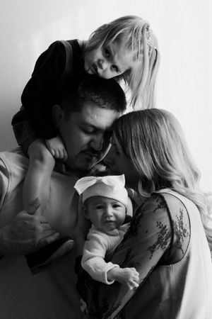 A series of black and white romantic photos showing tender moments between a couple and their baby.