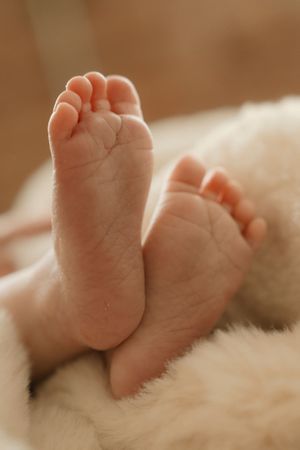 Close-up series of tiny newborn baby feet resting on soft white fabric showing different angles and details.