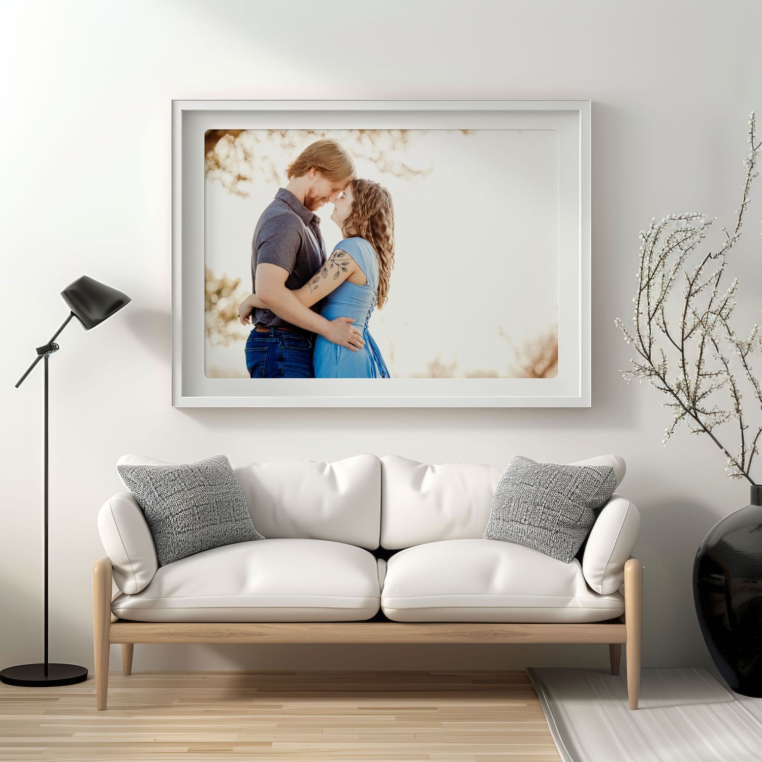 Framed family portraits and decorative plants adorn a modern living room with neutral tones and rattan furniture.