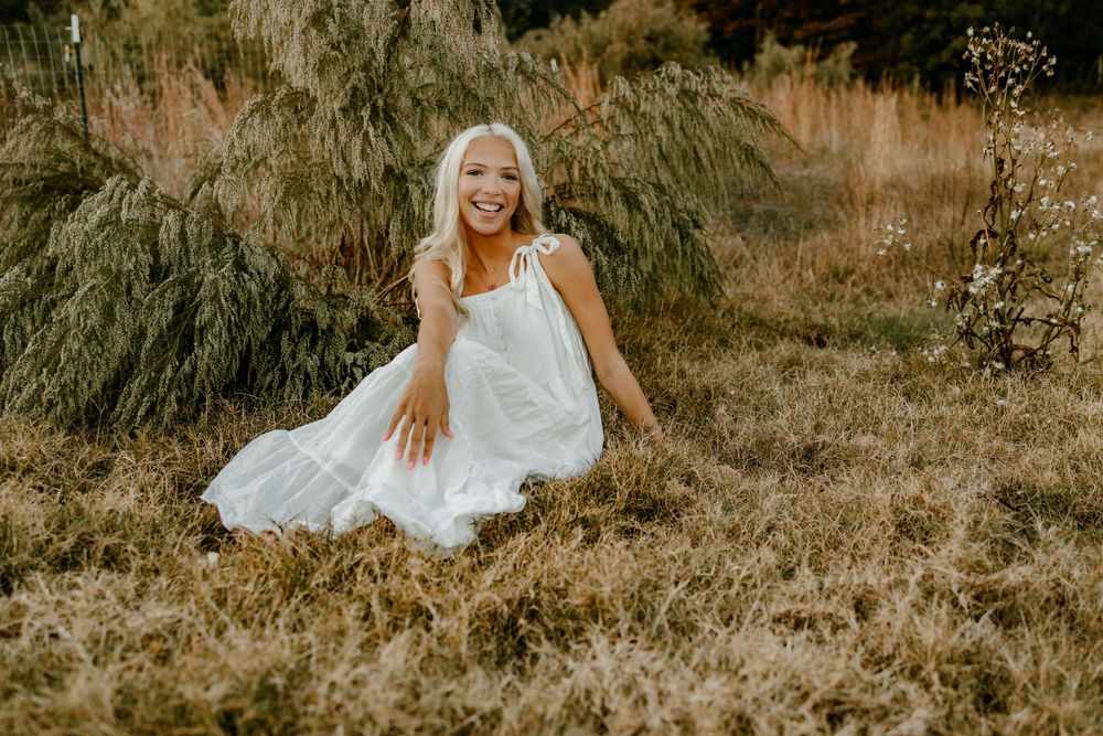 Artistic outdoor photography in a sepia-toned field with tall grass and natural autumn lighting.