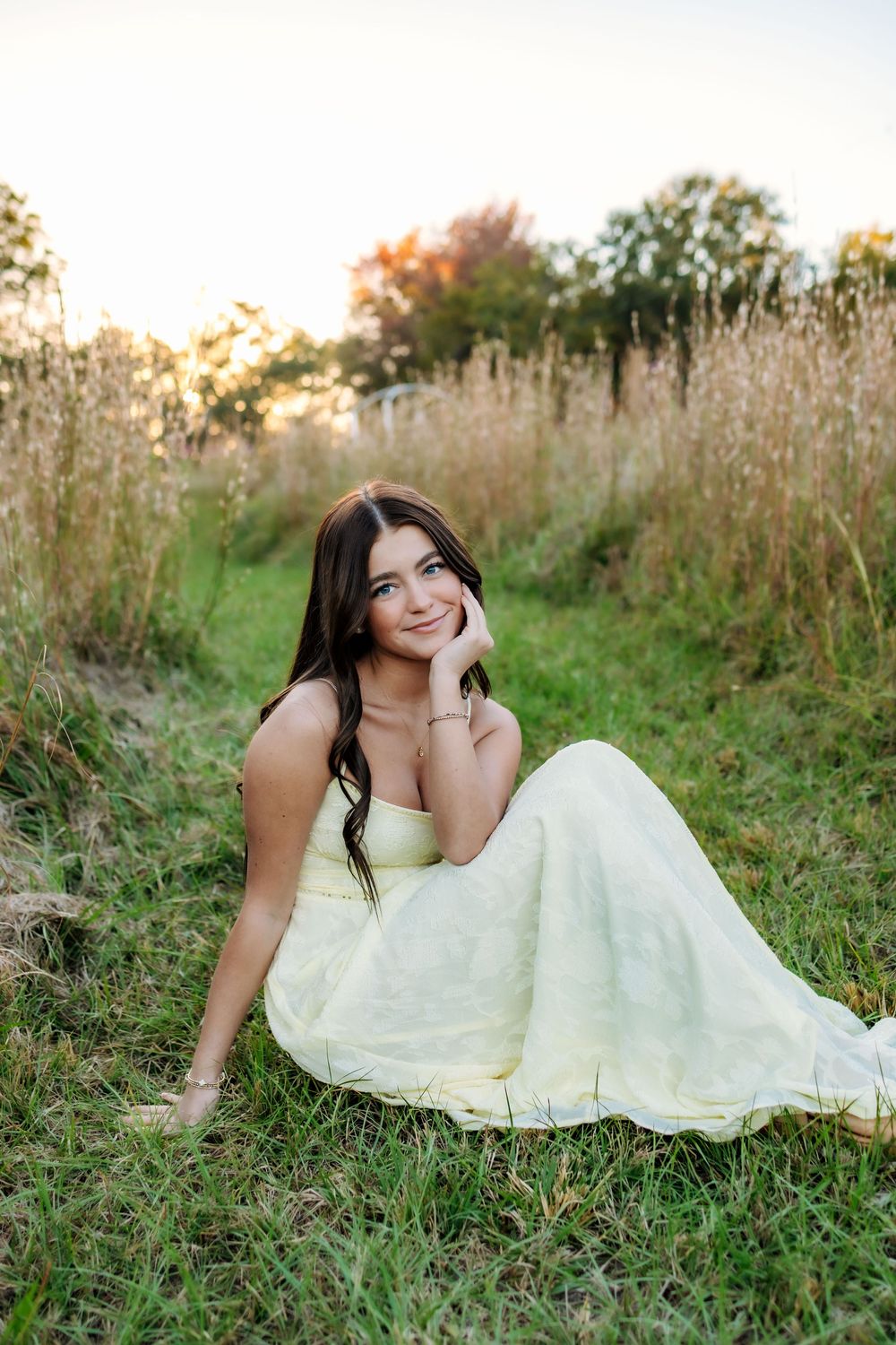Romantic outdoor photo shoot in a meadow with soft natural lighting and yellow dress.