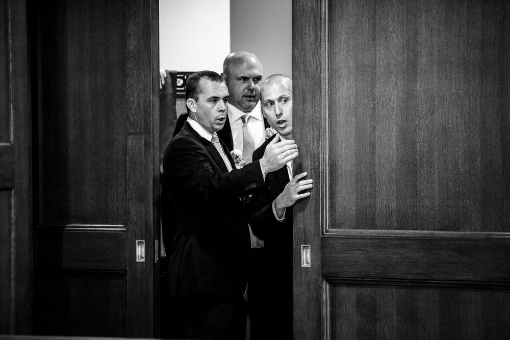 Wedding guests enjoying a formal reception in an elegant wood-paneled room.