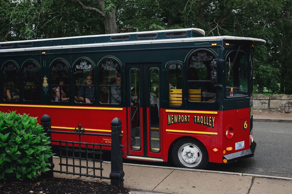 Red trolley buses parked in line at a tourist destination.