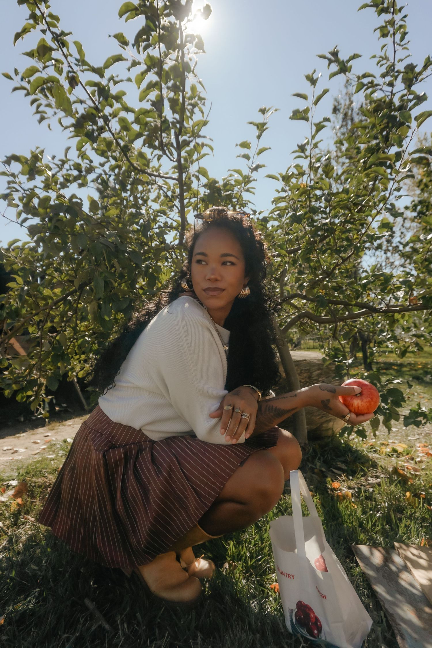 A series of photos showing a person in a green dress sitting on a white bench in natural lighting.