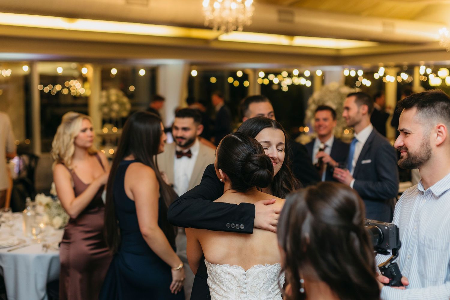 Chicago wedding photographer and videographer hugging a bride in the middle of dance floor