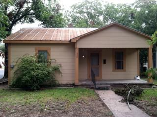 Exterior panorama of a beige residential home with covered porch and multiple windows.