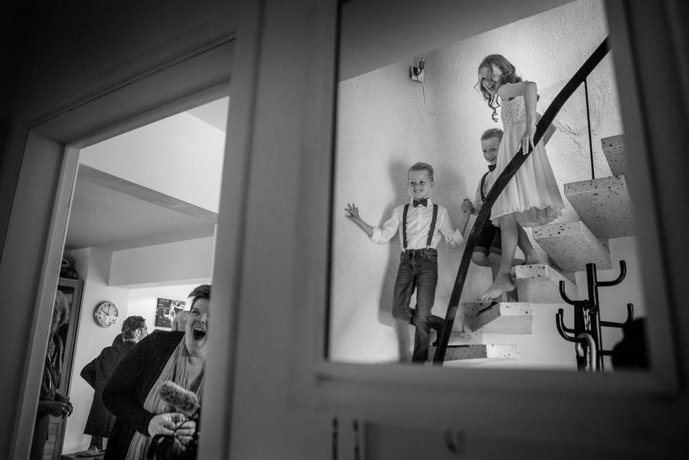Black and white image of figures silhouetted against windows in a home setting.