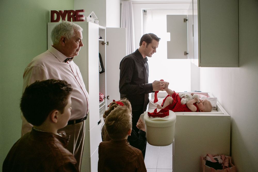 Interior scene showing an adult and child interacting in doorways of a home.