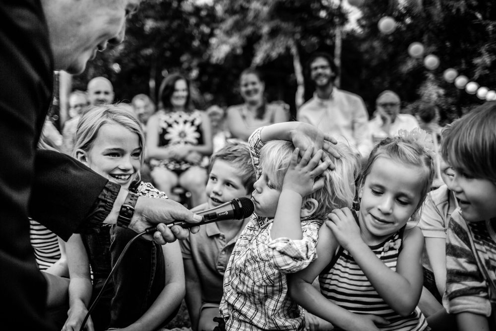 Young wedding guests share excited reactions during a special moment.