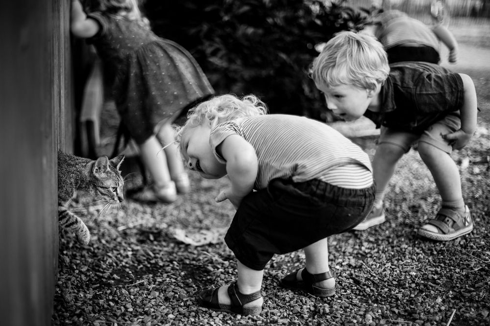 Kids exploring and playing on a gravel or stone surface outdoors.