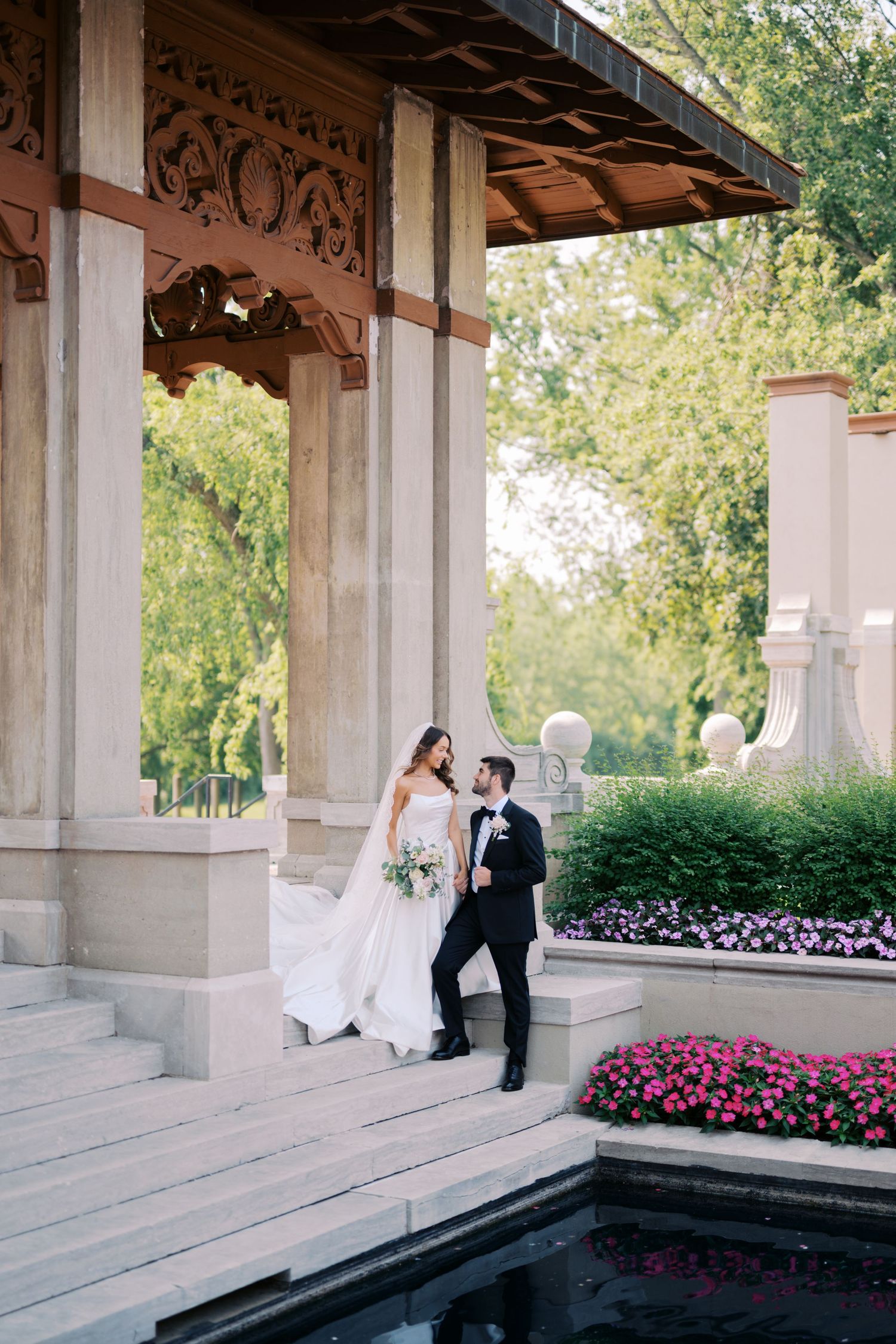 A romantic wedding photo sequence captured under an ornate columned pavilion with pink flowers in the background.