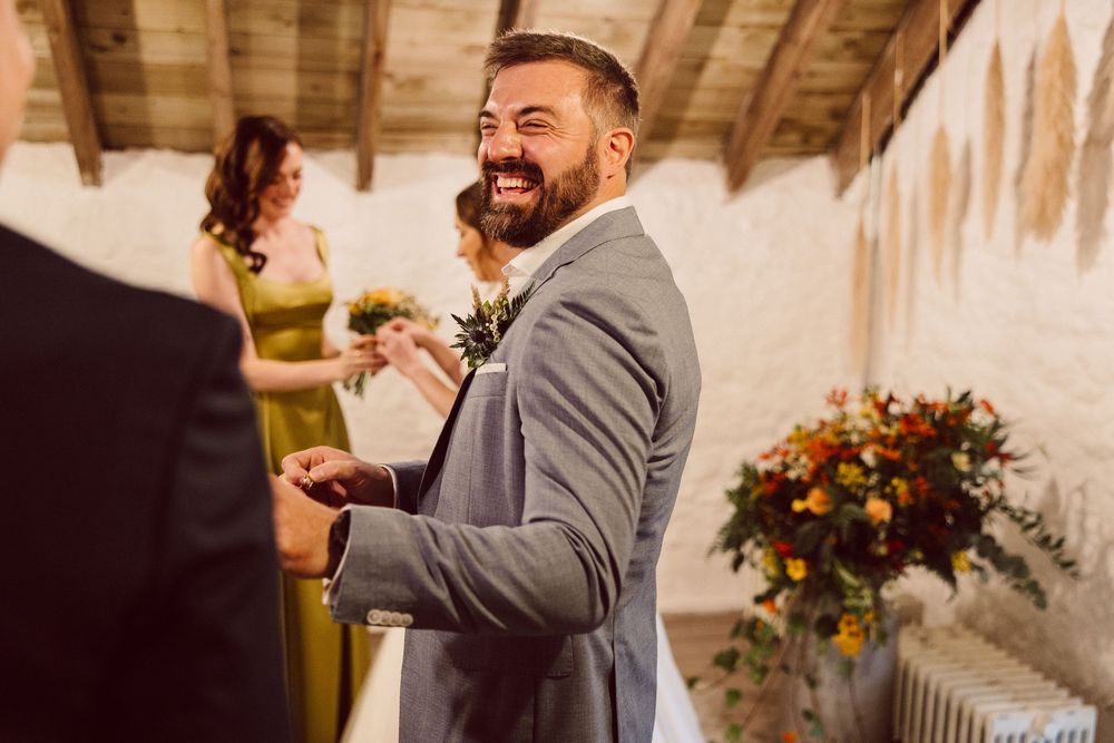 A joyful wedding celebration at a rustic venue with wooden beams and warm lighting.