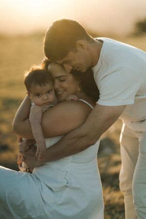 A tender moment between parent and child embracing outdoors during golden hour sunset.