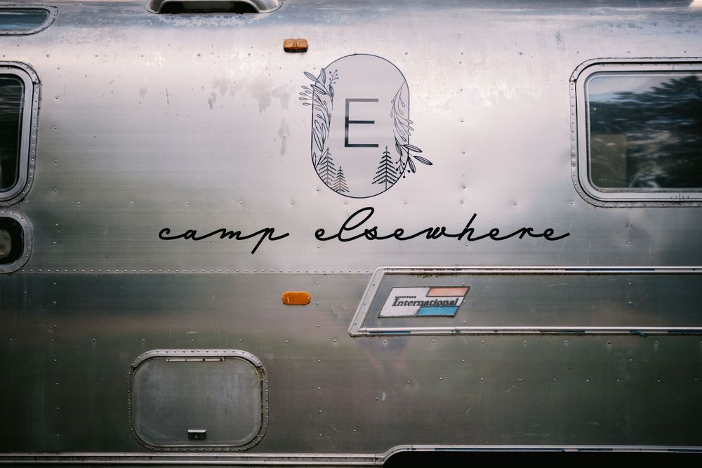 A series of vintage Airstream travel trailers lined up side by side showing their distinctive silver aluminum exteriors.