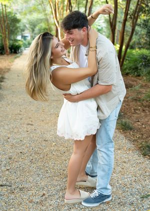 A couple shares romantic moments on a gravel path surrounded by lush greenery in a series of candid shots.