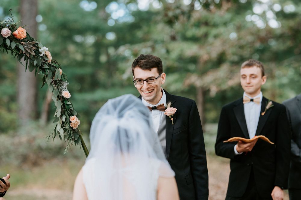 Wedding couple shares playful moments with oranges in a rustic outdoor garden setting.