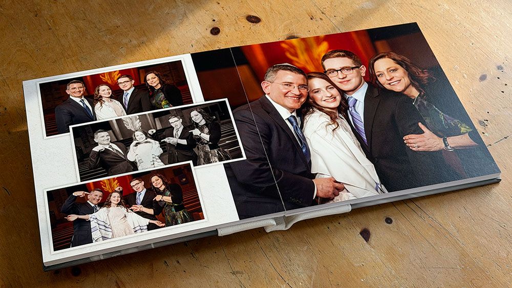 Multiple photo albums displayed in a line on a beige surface showing various photographs.