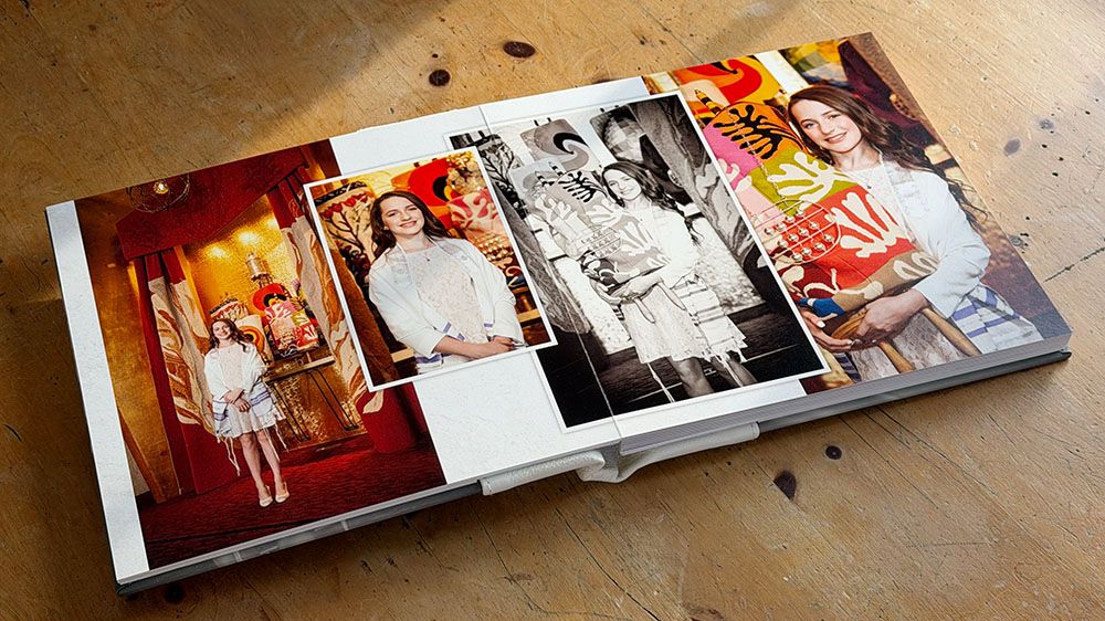 A collection of photo albums or books arranged in a row on a textured surface.