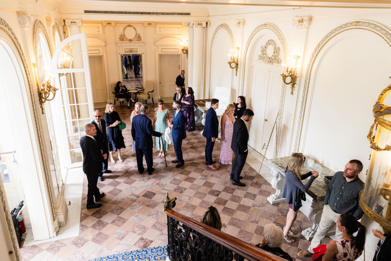 Guests gathered inside the marble foyer at Tupper Manor in Beverly, MA during an elegant wedding celebration.