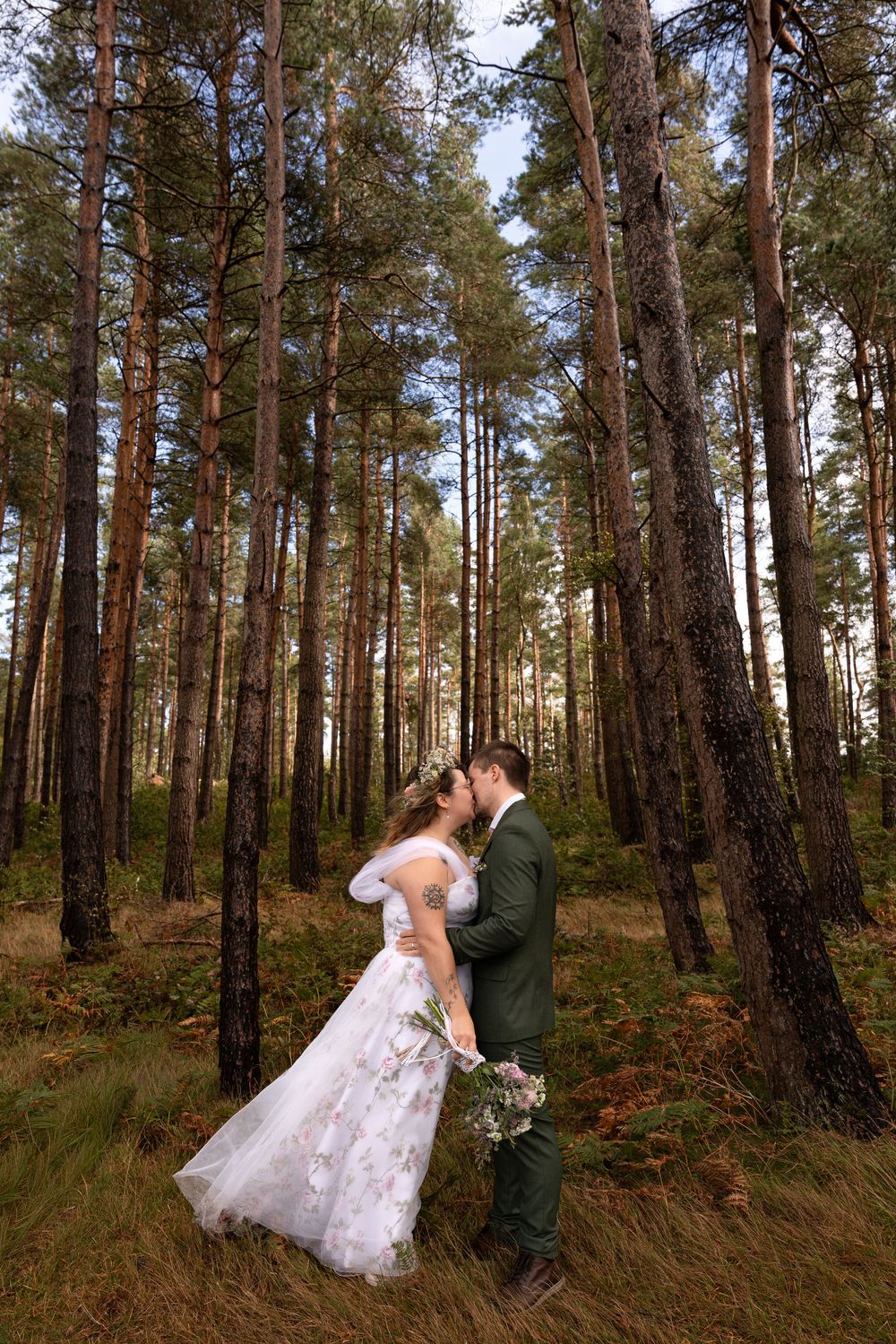 A romantic wedding photoshoot sequence in a pine forest with a couple embracing in a white dress and dark suit.