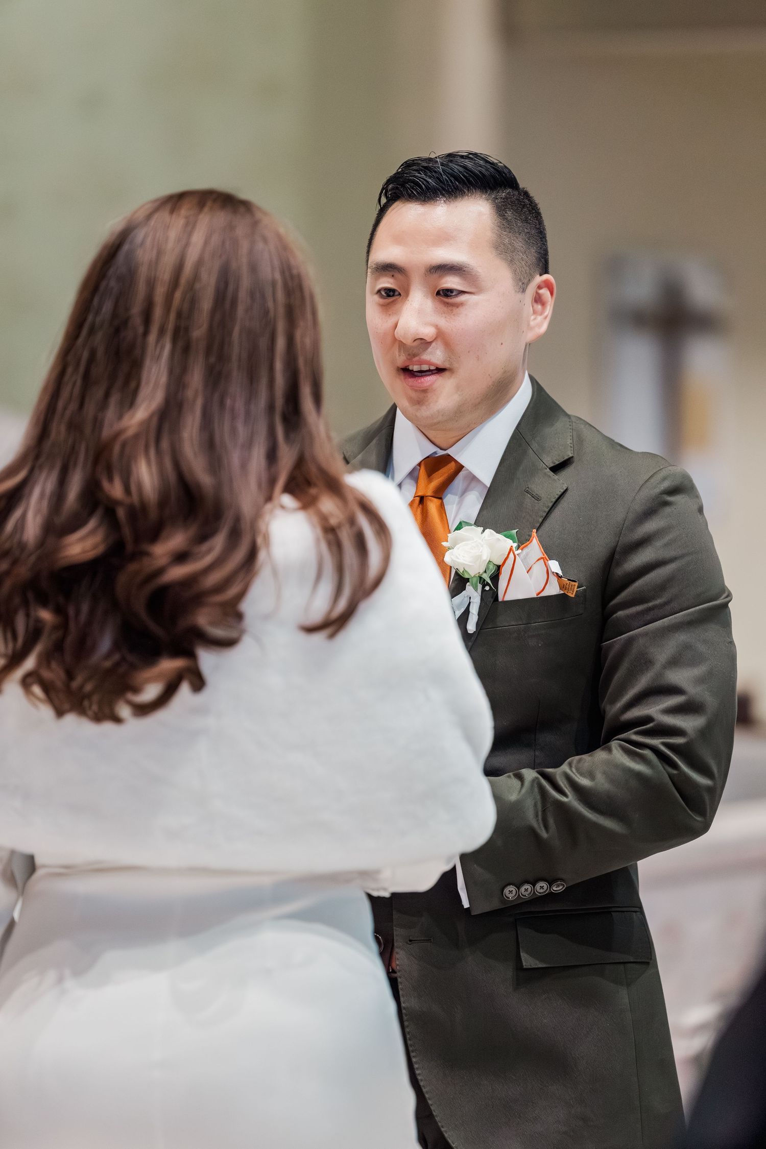 A couple in wedding attire share a romantic first dance moment in a ballroom setting.