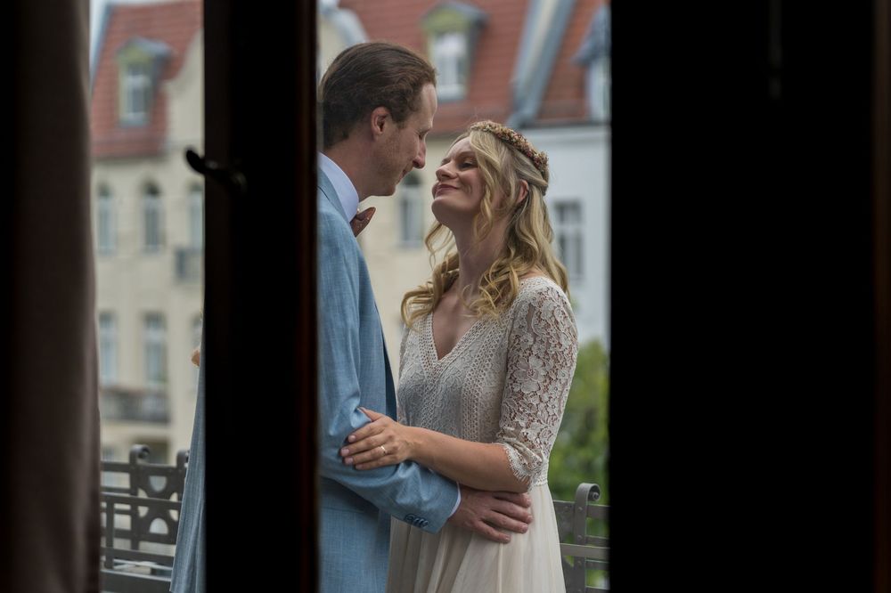 Hochzeitsfotograf Berlin – Brautpaar lacht sich an beim intimen Moment hinter der Tür