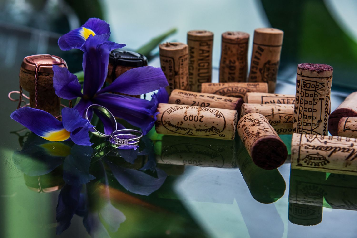 Wedding decorations featuring purple iris flowers and wine corks arranged in a rustic display.