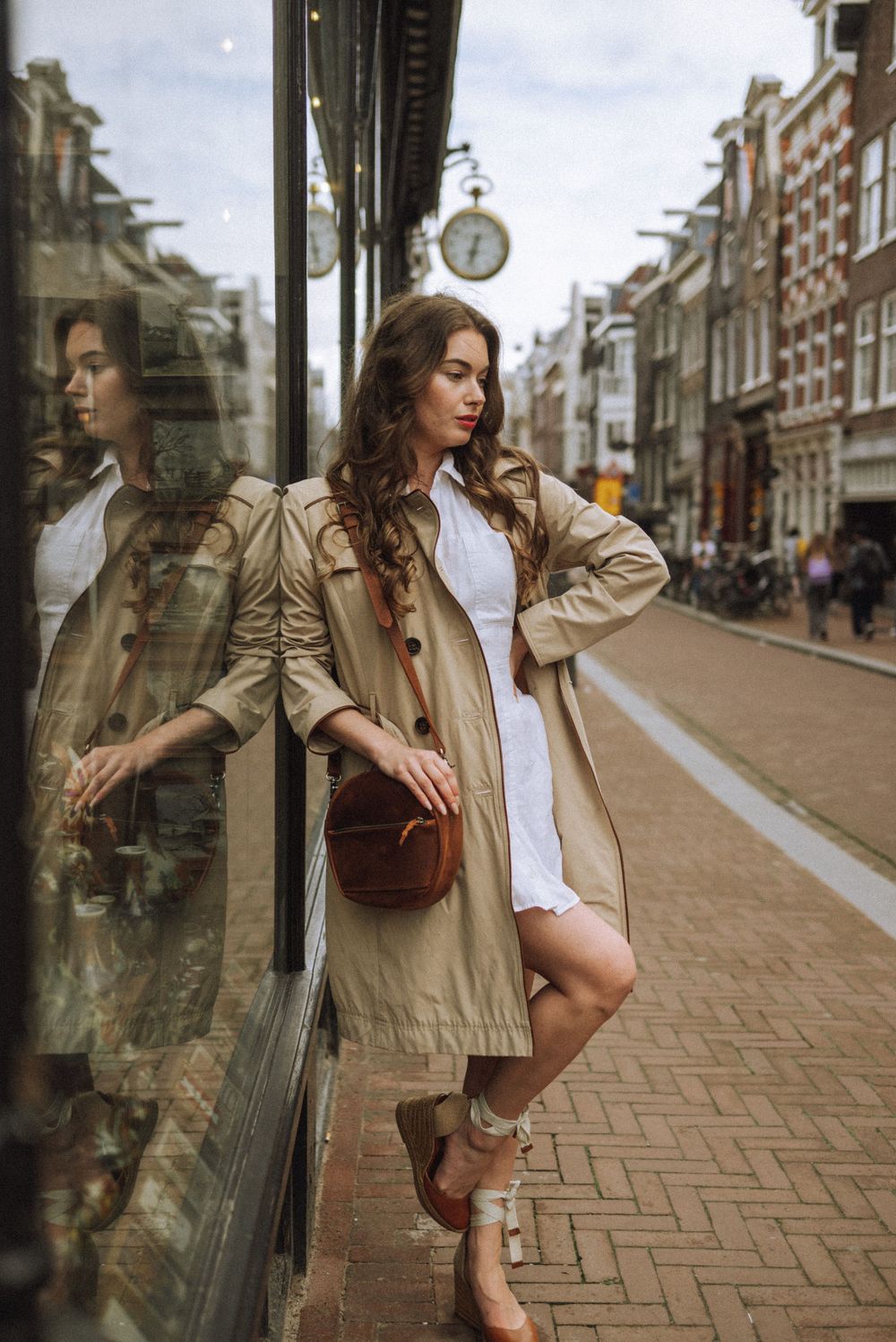 Artistic sequence showing reflections in storefront windows along Amsterdam's brick streets.