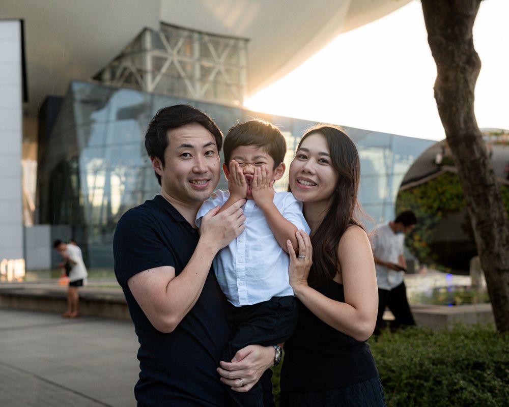 Outdoor family portrait with modern architecture and natural lighting.