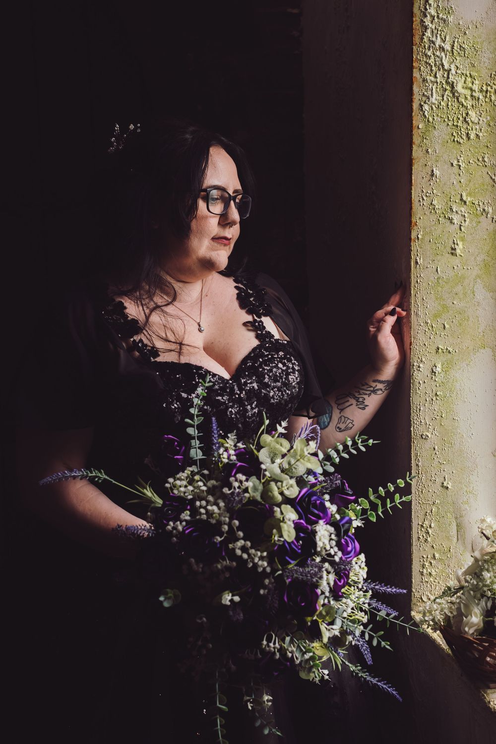 A moody portrait series shows a person in black holding a purple and white floral bouquet against a textured wall.