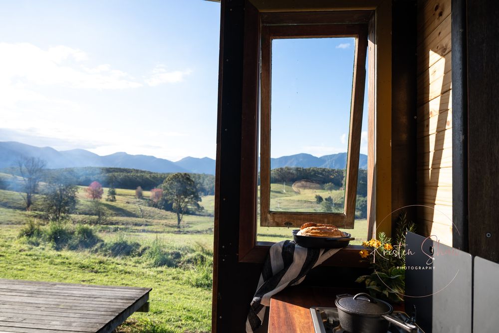 Mountain view visible through panoramic floor-to-ceiling windows in modern cabin interior with sloped ceiling.